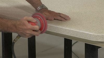sanding out any imperfections in the newly cut edge with an orbital sander