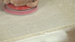 using orbital sander to sand away excess glue