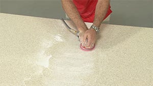 using orbital sander to sand away excess glue