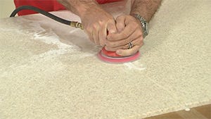 using an orbital sander to sand down excess glue