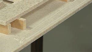 applying two beads of adhesive where the edge buildup will be placed